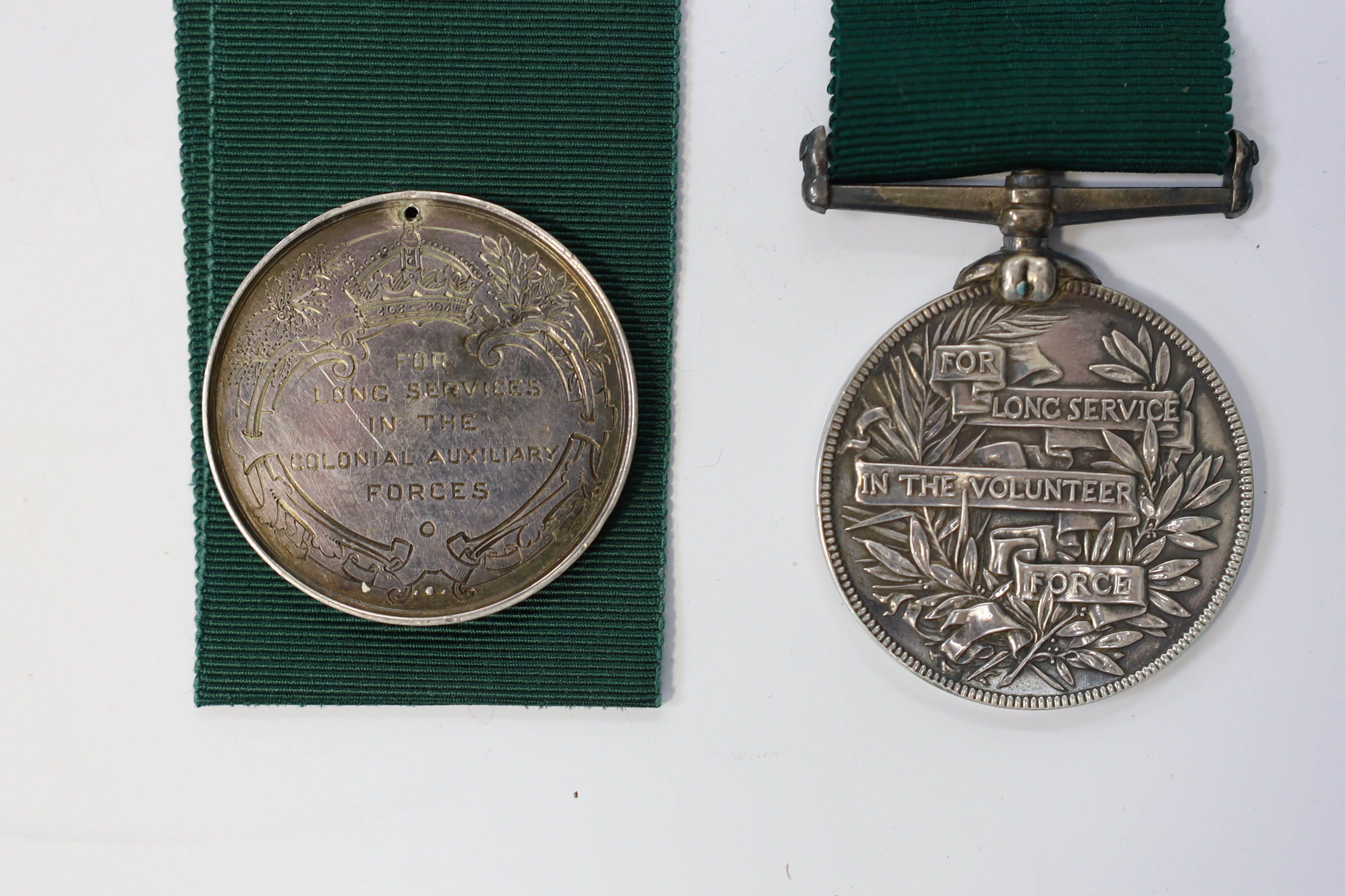 Four assorted Service medals; Vict unnamed Volunteer Long Service medal; GV Colonial Auxiliary Forces Long Service medal (disc only) to E.S.Ware; ERII ISM to Thomas Edward Downes; ERII ISM to William Henry Sharratt. Cond